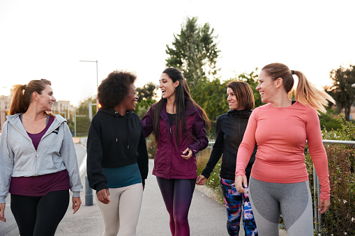 Een afbeelding van een groep vrolijke vrouwen die met elkaar een wandeling maken.